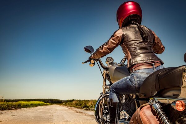 Biker girl on a motorcycle Biker girl in a leather jacket and helmet on a motorcycle