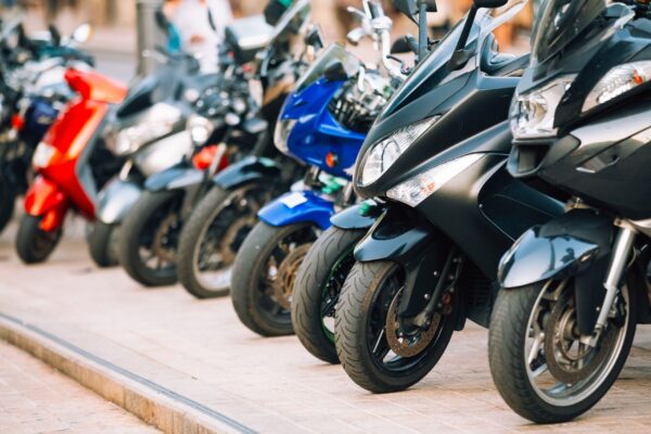 Motorbike, motorcycle scooters parked in row in city street Motorbike, motorcycle scooters parked in row in city street. Close up of wheel