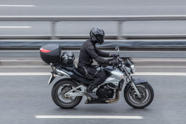 Motorcyclist in a helmet rides a motorcycle on the road. Motion blur.